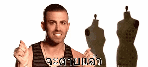 a man is pointing at a mannequin in front of a white background with a foreign language written on it .