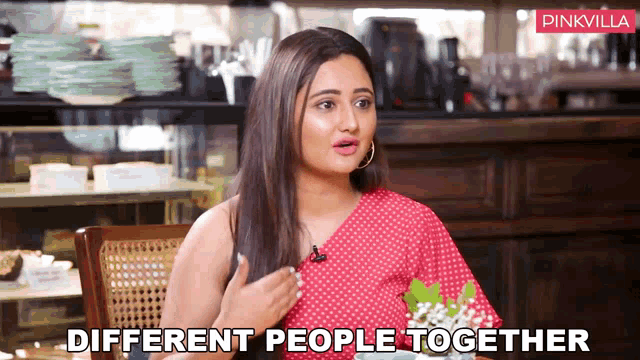 a woman in a red polka dot dress is sitting at a table with the words different people together written below her
