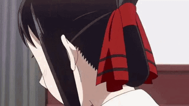 a close up of a girl 's head with a red bow in her hair