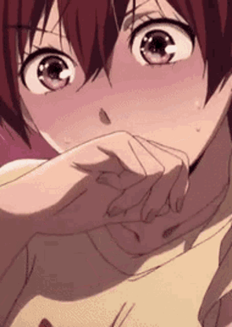 a close up of a girl with red hair covering her mouth with her hand .