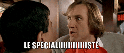 a man in a red bow tie talks to another man with the words le specialiste written on the bottom
