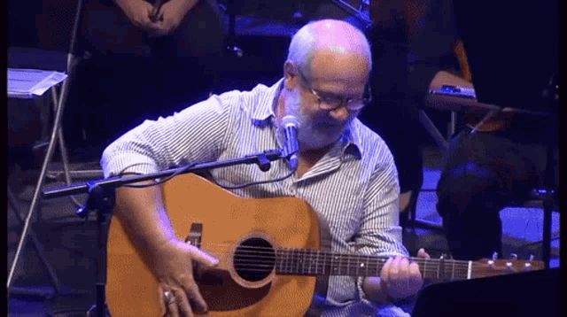 a man with a beard is playing an acoustic guitar