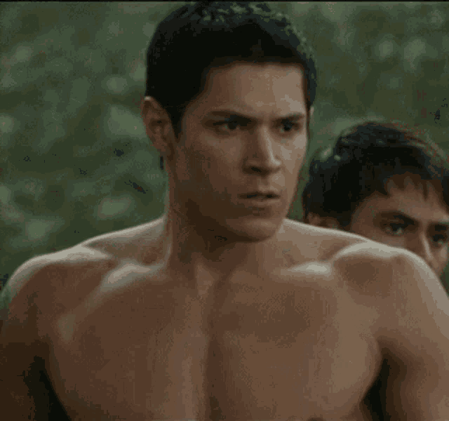a shirtless man is standing next to another man