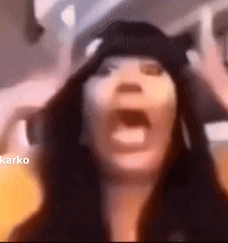 a close up of a woman 's face with her mouth open and a hat on .