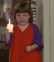 a young girl in a red dress is giving the middle finger .
