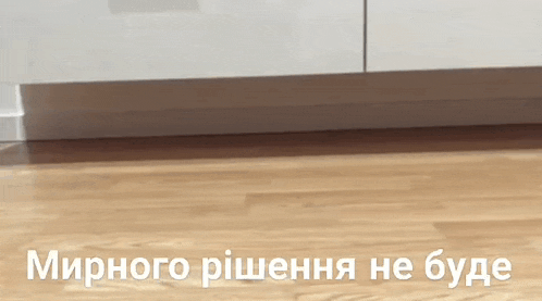 a wooden floor with the words " мирного рiшення не буде " in white letters