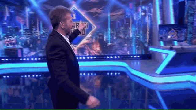 a man in a suit is dancing on a stage in front of a sign that says ' cbs ' on it
