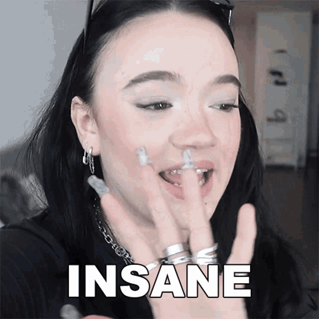 a woman with rings on her fingers has the word insane above her face