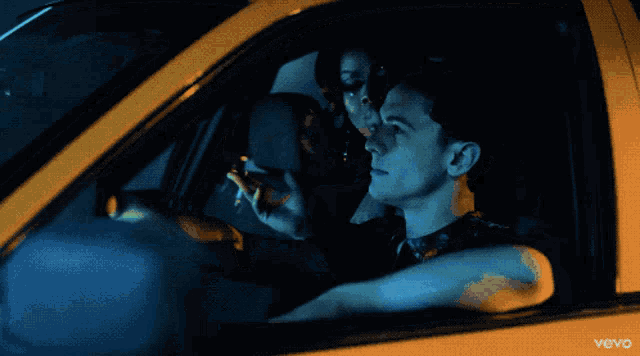 a man and woman in a car with the word vevo on the bottom left
