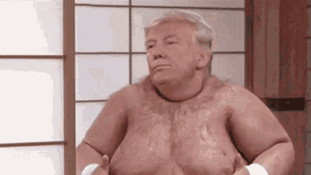 a shirtless man is standing in front of a window with his hands on his stomach .