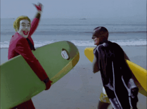 a man in a joker costume is holding a surfboard