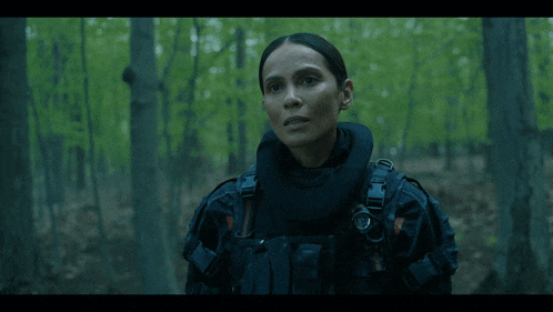 a woman in a military uniform stands in the woods with the words this it 's there above her