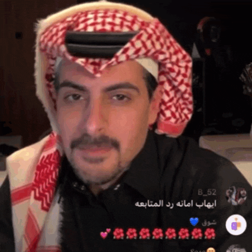 a man with a mustache wearing a head scarf and a black shirt