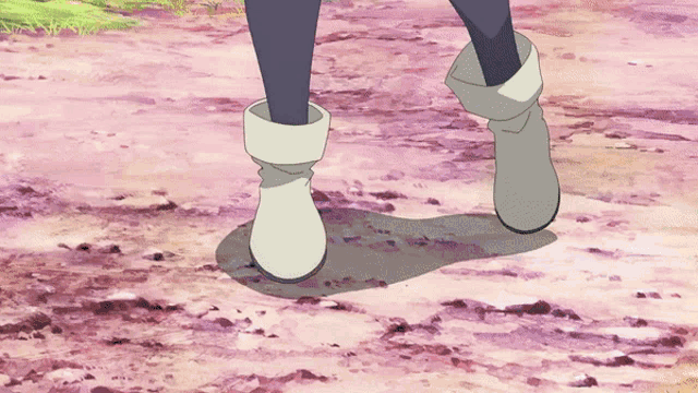 a person wearing white boots is walking on a dirt path