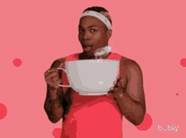 a man in a red shirt is holding a white cup with the word girl written on it