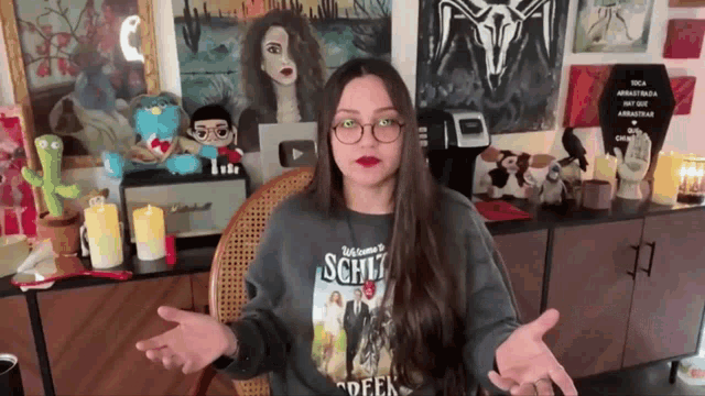 a woman wearing a shirt that says welcome to schlitz is sitting in a chair