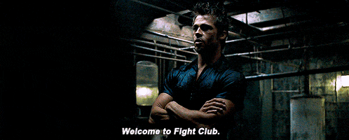a man with his arms crossed is standing in a dark room and says welcome to fight club
