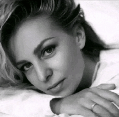 a woman with a ring on her finger is laying down