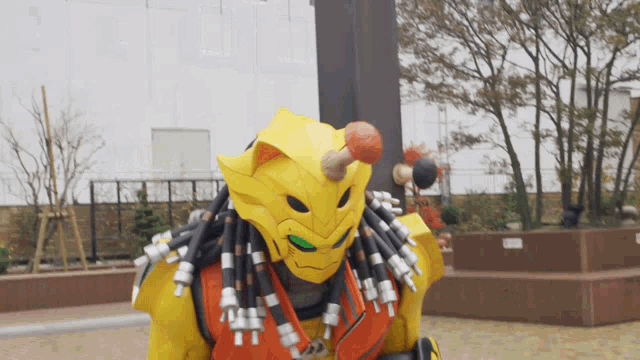 a yellow predator with dreadlocks is standing in front of a pole