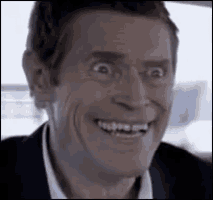 a man in a suit is smiling and making a funny face