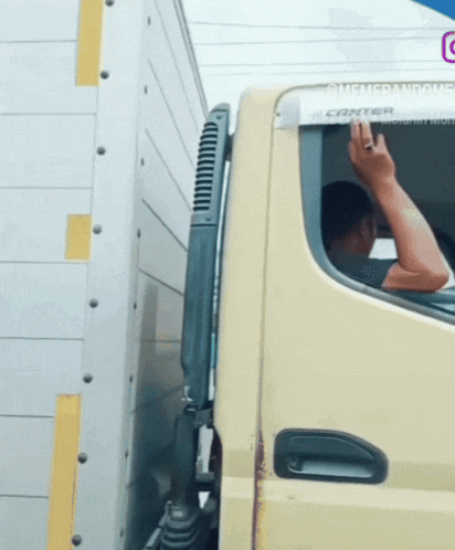 a man is driving a canter truck and making a rude gesture