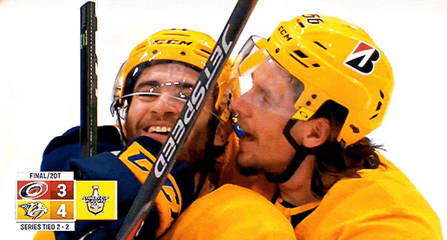 two ice hockey players are hugging and one has a helmet that says ccm