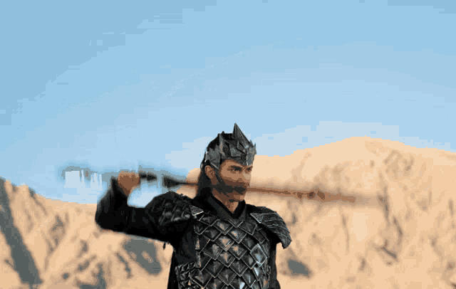 a man in armor holds a sword in the air