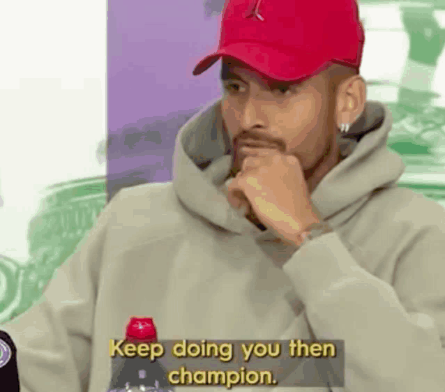 a man wearing a red hat and a hoodie says " keep doing you then champion "