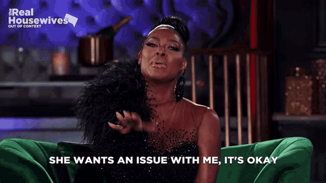 a woman sits on a green couch with the words she wants an issue with me it 's okay