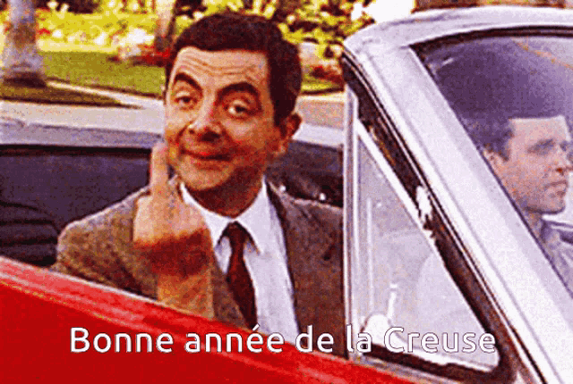 a man in a suit and tie is giving the middle finger in a car with the words bonne annee de la creuse below him