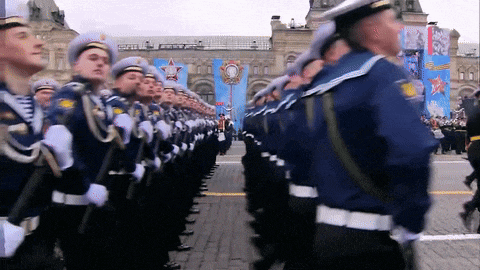 a group of soldiers marching in a parade with a banner behind them that says ' russia '