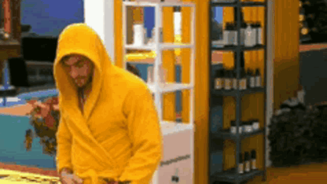 a man in a yellow robe is standing in front of a shelf with bottles on it