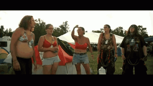 a group of women standing in front of a tent with one wearing a shirt that says ' i am a biker '
