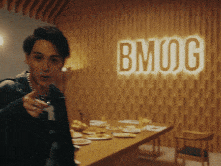 a man stands in front of a bmog sign