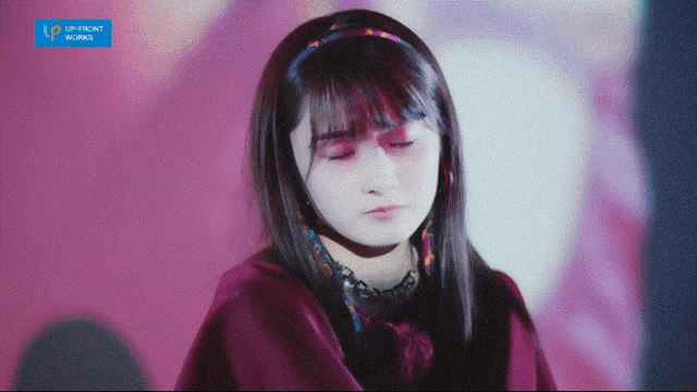 a girl with her eyes closed and a blue sign that says up-front works
