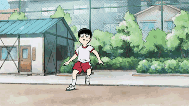 a boy in a white shirt and red shorts is running