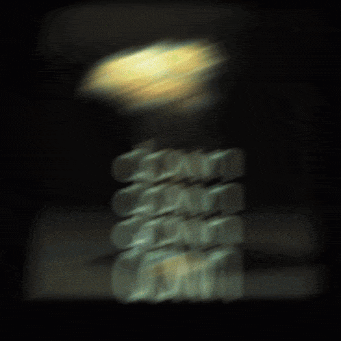 a blurred image of a stack of coins with a light behind them