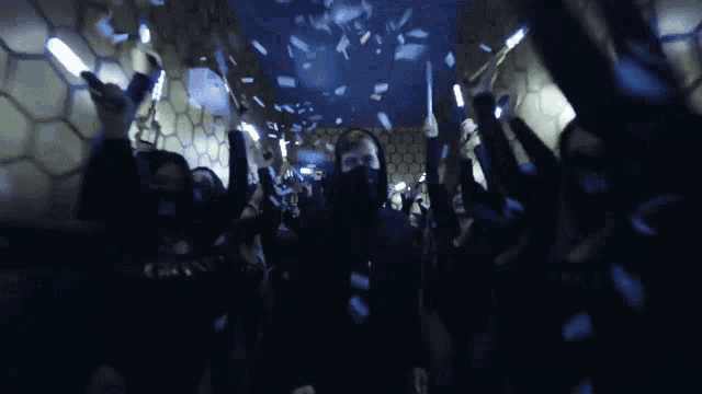 a crowd of people are holding glowing sticks in their hands