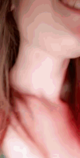 a close up of a woman 's neck and mouth with a pink background .