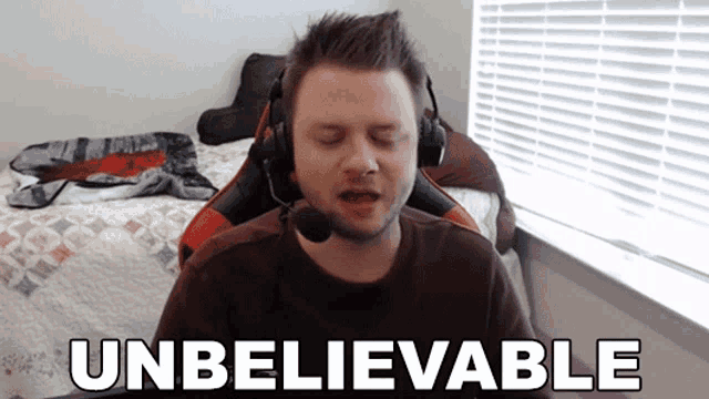a man wearing headphones is saying unbelievable in front of a window