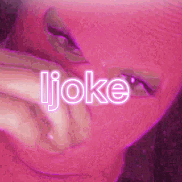 a close up of a person 's face with the word joke written in neon