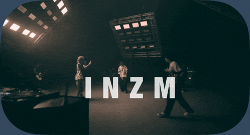 a man singing into a microphone with the word inzm on the bottom right