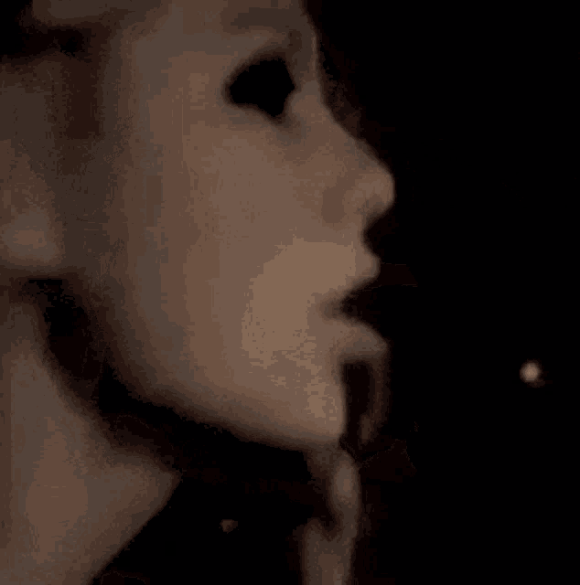 a close up of a person covering their face with their hand .