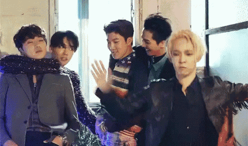 a group of young men are standing next to each other in a room