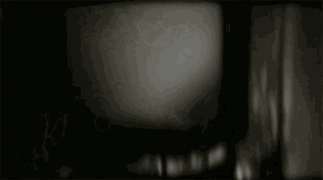 a dark room with a few spots of light on the wall