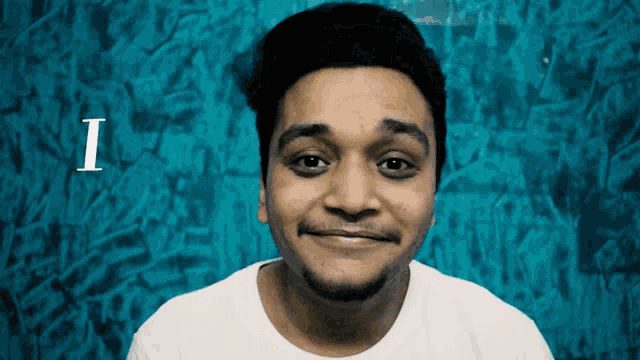 a man is smiling in front of a blue background with the letter i visible