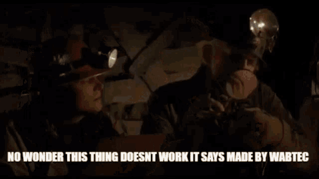 a man in a hard hat is talking to another man in a cave .