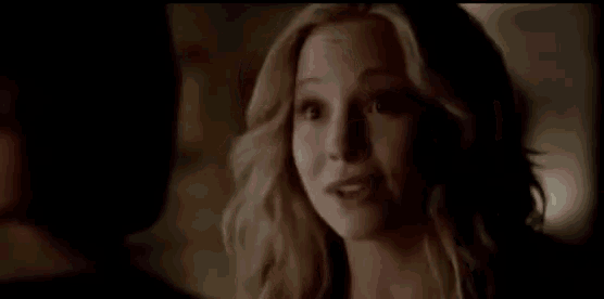 a close up of a woman 's face in a dark room talking to a man .