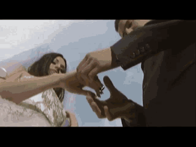 a man is putting a wedding ring on the finger of a bride .