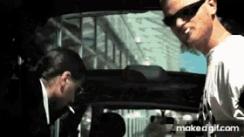 a man is smoking a cigarette in the back of a car